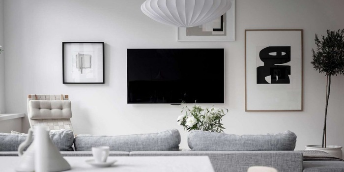 Il existe de nombreuses façons d'intégrer élégamment un téléviseur dans son intérieur, par exemple avec une mosaïque de photos. Photo : bjurfors.se